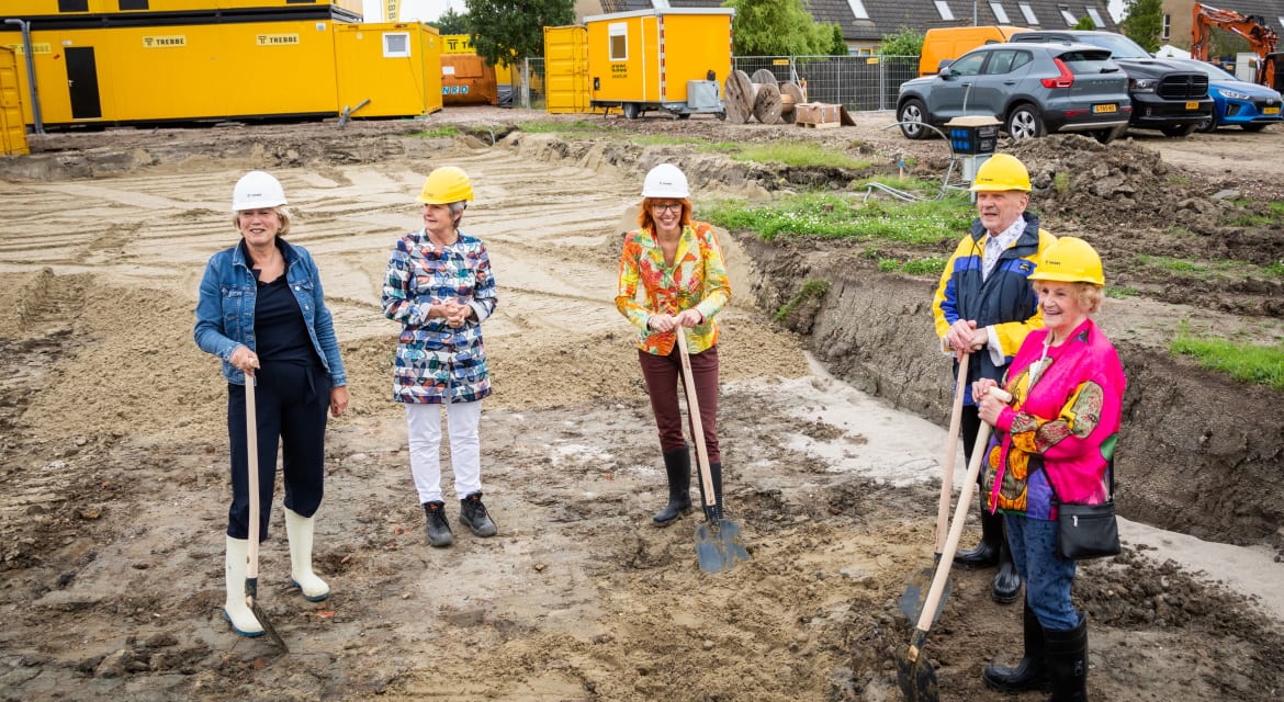 Anita Tijsma (Acantus), Annalies Usmany-Dallinga (wethouder Eemsdelta) en twee huurders hebben voor de start van het bouwproject bij de Fortressestraat in Delfzijl een tijdcapsule gevuld en begraven. Foto: Acantus / Huisman Media
