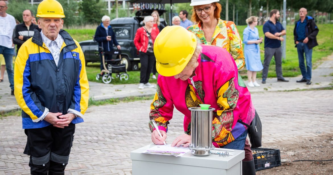 Anita Tijsma (Acantus), Annalies Usmany-Dallinga (wethouder Eemsdelta) en twee huurders hebben voor de start van het bouwproject bij de Fortressestraat in Delfzijl een tijdcapsule gevuld en begraven. Foto: Acantus / Huisman Media